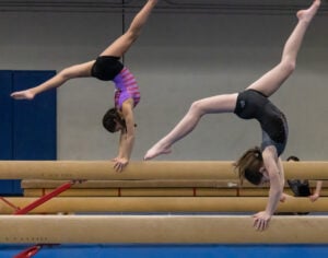 photo of two gymnasts on balance beam